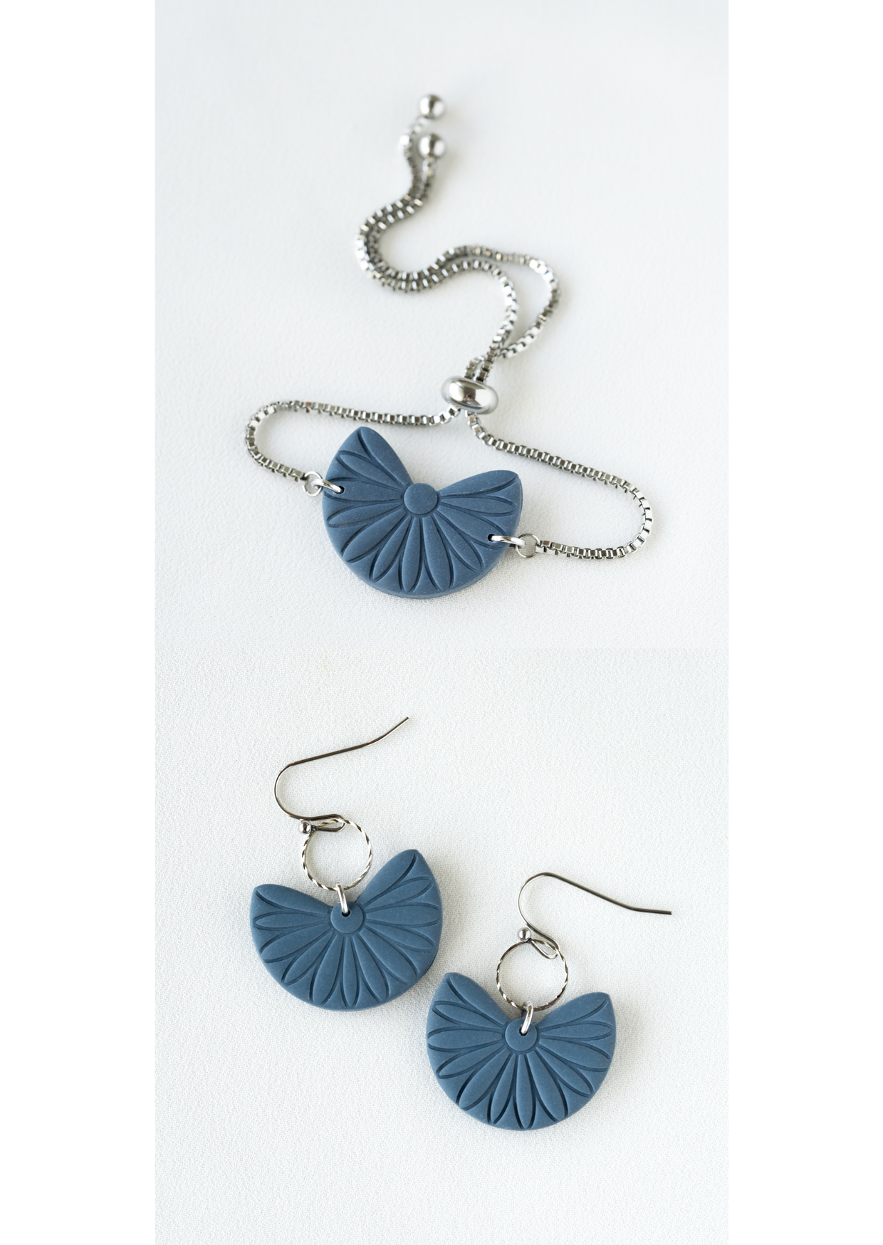 Polymer clay earring and bracelet jewelry set with blue fan-shaped pendants on a white background.