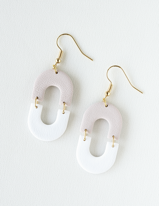 White earrings with gold hooks on a white background