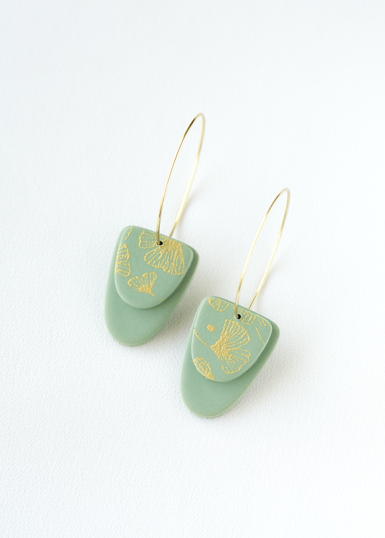old plated stainless steel hoop earrings with green and gold accents made of polymer clay.