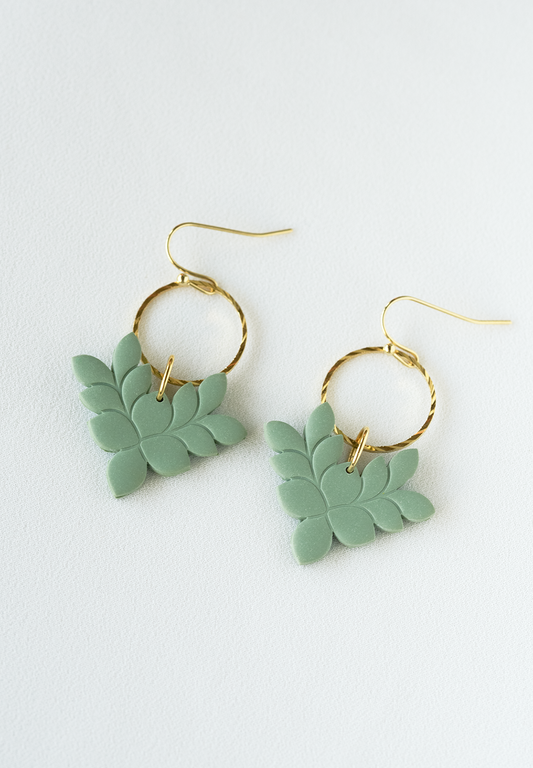 Green leaf-shaped polymer clay earrings with gold pated stainless steel hooks on a white background.