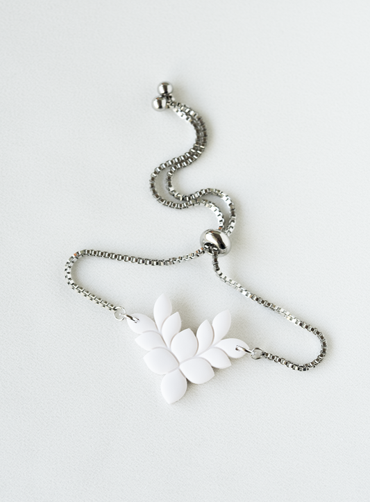 adjustable stainless steel bracelet with a white leaf pendant on a white background