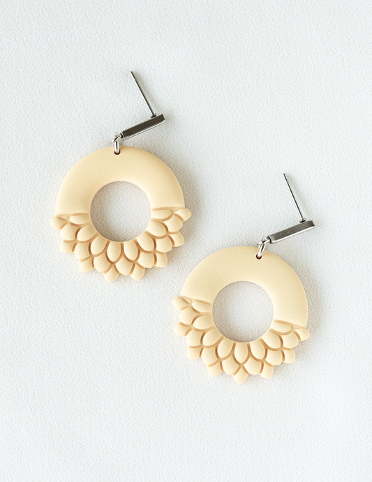 Pair of peach fuzz colored polymer clay dangle earrings with stainless steel findings on a white background.