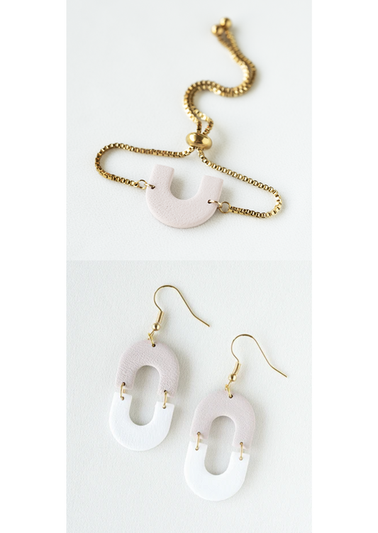 Polymer clay earring and bracelet jewelry set with two-tome arch pendants on a white background.