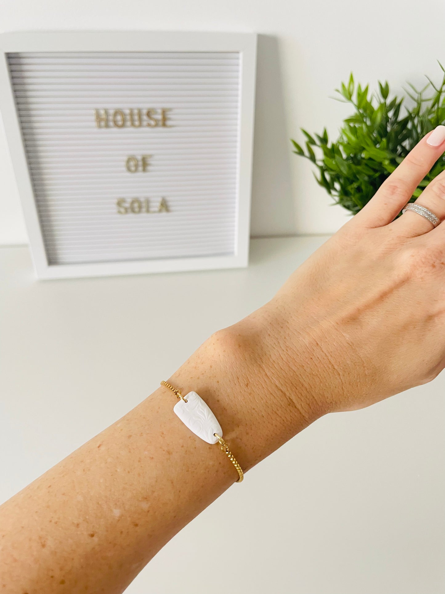 CYPRUS hand-crafted adjustable stainless steel bracelet with white leaf polymer clay ornament on wrist, floral texture