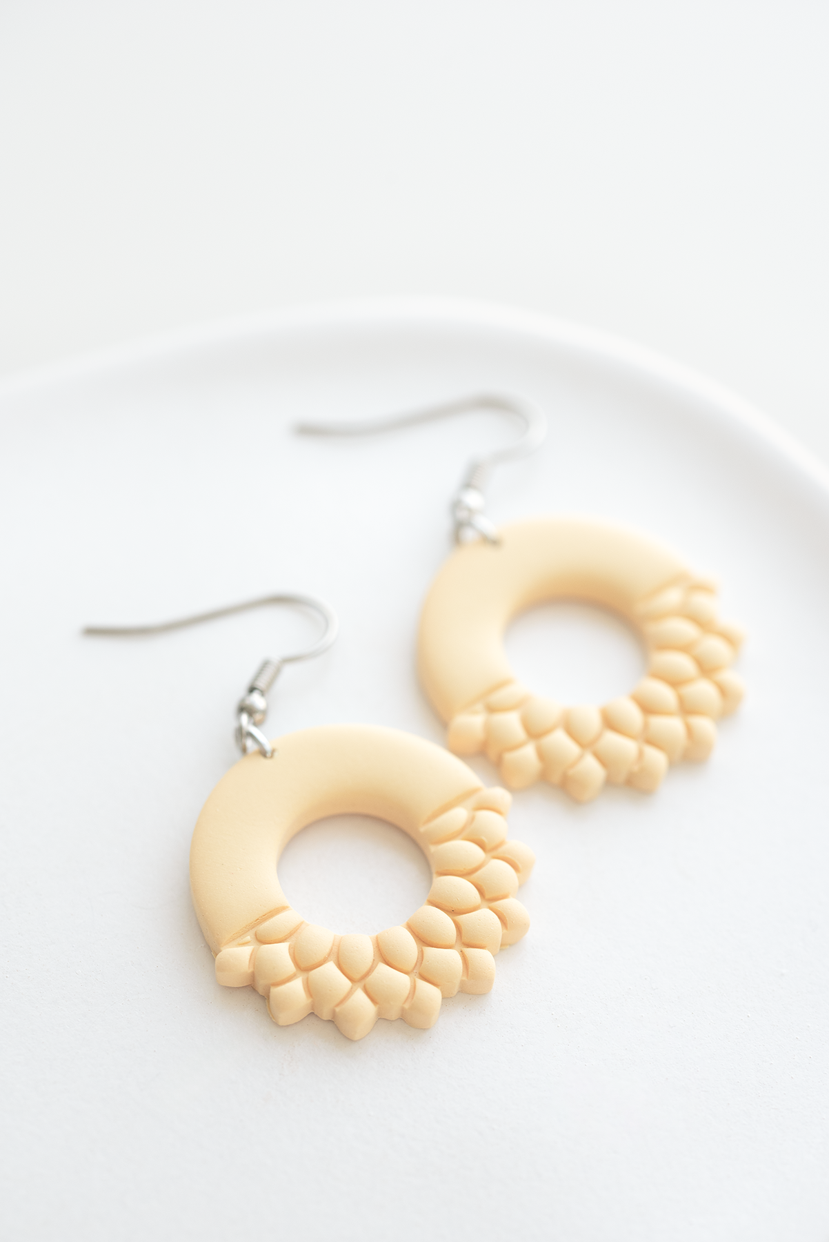 PARIS polymer clay earrings in peach fuzz color polymer clay dangle earrings, round with leaf accents, stainless steel, made in Dubai